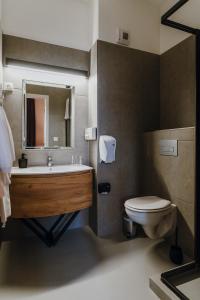 塞格德Hotel Piano的一间带水槽、卫生间和镜子的浴室