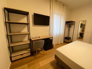 瓦雷泽FORESTERIA DANSI的一间卧室配有一张床、一张书桌和一台电视