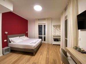 瓦雷泽FORESTERIA DANSI的卧室配有白色的床和红色的墙壁