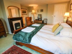 康福斯Langthwaite Cottage的一间卧室配有一张大床,上面有绿毯