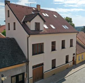 贝希涅Apartmány Bechyně的白色的建筑,带有棕色的屋顶