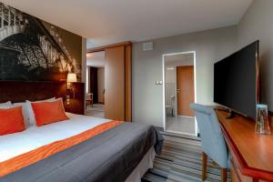 华沙华沙中心美居酒店的酒店客房配有一张床和一张书桌及一台电视
