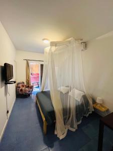 达喀尔La Cabane du Pêcheur Atlantic Evasion的一间卧室配有一张带天蓬的床