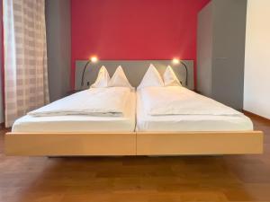 卢塞恩Hotel Rothaus Luzern & Peruvian Culinary Art的红色墙壁的客房内设有两张单人床