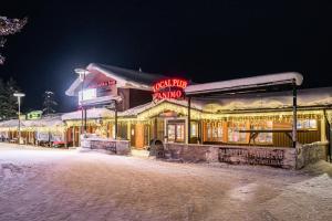 萨利色尔卡萨利色尔卡啤酒旅馆的一条雪 ⁇ 街道上带有 ⁇ 虹灯标志的建筑