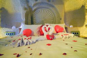 内夫谢希尔Babili Cappadocia Cave Hotel的一张床上,里面装着红桃和气球