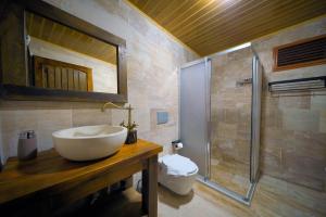 内夫谢希尔Babili Cappadocia Cave Hotel的浴室配有白色水槽和淋浴。