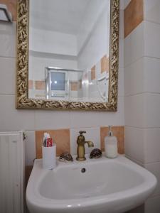 特里波利斯comfort apartment的浴室设有白色水槽和镜子