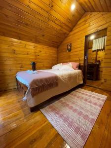 MachachiGlamping El Reencuentro的小木屋内一间卧室,配有一张床