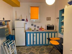波多河丽Granatapfel的厨房配有蓝白色冰箱和桌子