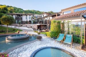 道尼库宾Villa Helia的后院设有游泳池、两把椅子和房子