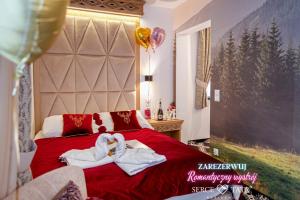 扎科帕内Serce Tatr Residence Zakopane - blisko Krupówek的一间卧室配有一张床,上面有两条毛巾
