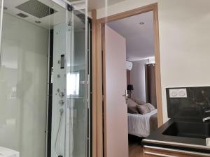 佩皮尼昂Appart Hotel Spa Perpignan的一间带玻璃淋浴和水槽的浴室