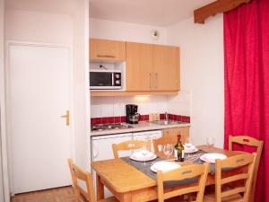 皮伊圣万桑Appartement Puy-Saint-Vincent, 3 pièces, 6 personnes - FR-1-504-106的一间带木桌和椅子的厨房以及一间用餐室