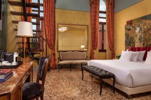 威尼斯NH Collection Grand Hotel Palazzo Dei Dogi的一间卧室配有一张床、一张桌子和一把椅子