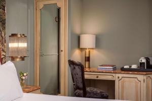 威尼斯NH Collection Grand Hotel Palazzo Dei Dogi的一间卧室配有一张桌子、一把椅子和一盏灯