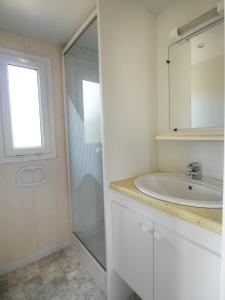 Saint-Georges-de-LuzençonVAL ST GEORGES的白色的浴室设有水槽和淋浴。