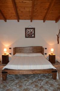 贡内萨Giardino degli Ulivi的一间卧室配有一张床,两台桌子上放着两盏灯