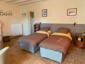 Poncé sur Le LoirLA PONCÉ SECRÈTE的一间设有两张床铺的房间,房间配有桌子