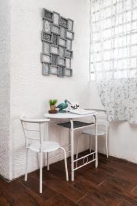 多拉多1 BR, Dorado beach apartment 20% monthly discount的一张带两把椅子的白色桌子和一株植物