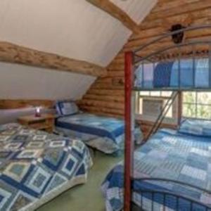 BrownfieldBig Sky Mountain Estate的小屋内设有一间带三张双层床的卧室