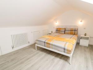 波特马多克Cartref Clyd 55的一间白色客房内的床铺卧室