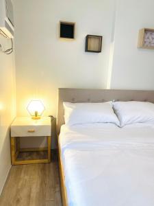 巴科洛德Cozy Condo bedroom in Bacolod City的卧室配有一张床,床头柜位于床边。
