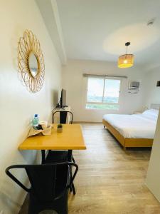 巴科洛德Cozy Condo bedroom in Bacolod City的客房设有一张床、一张桌子和一张书桌。