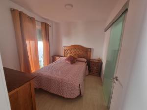 萨各夫雷纳A 600m de la playa, terraza soleada的一间卧室配有一张床、一个梳妆台和一扇窗户。