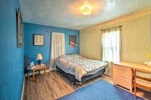 CircleCharming Corral Creek Ranch House in Circle的一间拥有蓝色墙壁的卧室,配有一张床和一张桌子