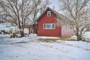 CircleCharming Corral Creek Ranch House in Circle的雪中带长凳的红色房子