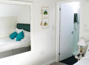 圣贾斯特Cape Cornwall Club的卧室内床的镜子反射