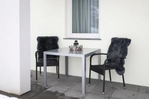 皮茨河谷阿兹尔Haus Raich - Pitztal Card im Sommer inklusive的一张带两把黑色椅子的白色桌子和一张带玻璃碗的桌子