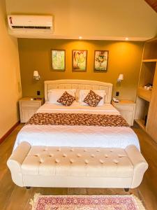 彼得罗波利斯Chalés Princesa Isabel的一间卧室配有一张大床和白色沙发