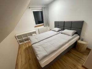 伊斯泰布纳Dom Pod Świerkami的卧室配有一张带白色床单的大床和窗户。