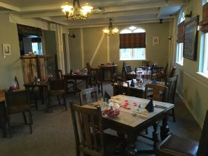 里斯伯勒王子城The Red Lion Longwick, Princes Risborough HP27 9SG的用餐室配有木桌和椅子