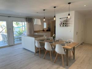 圣马丁岛Orient Bay, Appartement Héliconia.的厨房以及带木桌和椅子的用餐室。