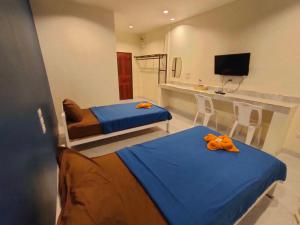 SadaoBanana Resort Sadao的一间卧室配有两张带橙色弓的床铺。