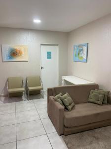 伊瓜苏Ap flat central- ar, garagem e ótima localização的一间配有沙发和两把椅子的等候室