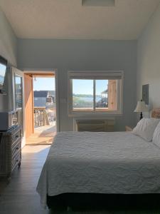 蒙托克蒙托克太阳与声音酒店的一间带大床的卧室和一个阳台