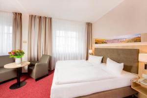 塞巴特阿尔贝克佳妮艾登酒店的卧室配有一张白色大床和一把椅子