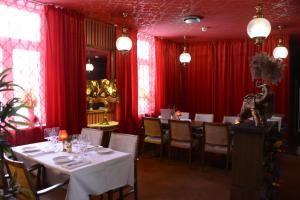 格兰纳Örserumsbrunn Gestgifveri的一间配备有桌椅和红色窗帘的用餐室