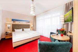 塞巴特阿尔贝克Hotel Garni Sonne的酒店客房带一张床、一张桌子和椅子