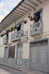 SalaminaLa Estancia Hotel Boutique的白色的建筑,设有两个阳台和两个门
