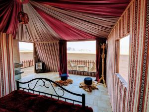 瓦迪拉姆Desert Magic Camp & Resort的一间卧室配有一张床,享有海滩美景