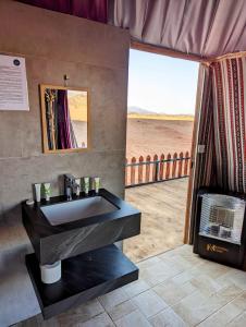 瓦迪拉姆Desert Magic Camp & Resort的设有带水槽的浴室,享有海滩美景