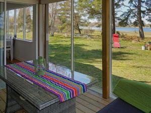 Bergkvara6 person holiday home in BERGKVARA的门廊上带彩色毯子的桌子的屏蔽