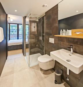 卢塞恩Liv Suites的带淋浴、卫生间和盥洗盆的浴室
