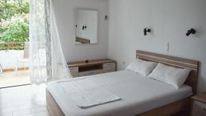 艾迪普索斯Ελαία Apartments的一间白色卧室,配有床和阳台