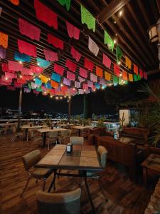瓜纳华托Hotel 1988 Guanajuato的餐厅设有桌椅和色彩缤纷的旗帜